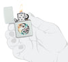 Zippo Floral Yin and Yang Design Glacier Windproof Lighter lit in hand.