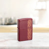 Lifestyle image of Zippo Heart Garland Design Merlot Windproof Lighter standing on a marble countertop.