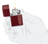Zippo Heart Garland Design Merlot Windproof Lighter lit in hand.