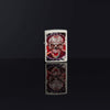 Lifestyle image of Skull Design Mercury Glass Windproof Lighter standing in a black background, with its design reflecting on the group.