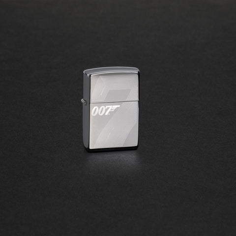 Lifestyle image of James Bond 007™ Auto Engraved High Polish Chrome Windproof Lighter standing in a black scene.